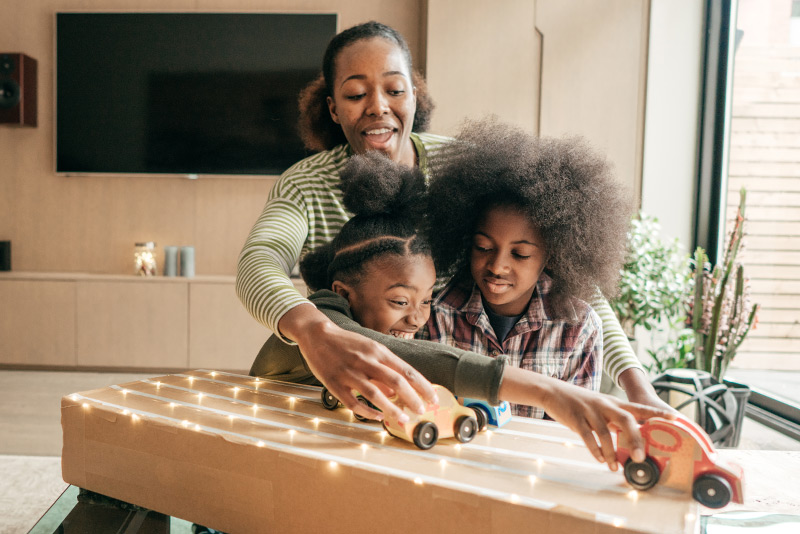 A young mother plays with her children in a renovated family room financed by a home improvement loan