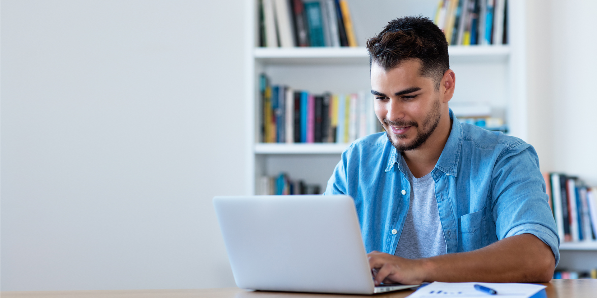 Young man typing on a laptop.