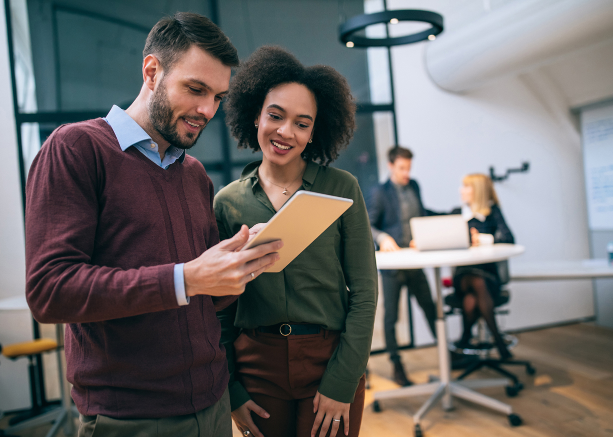 Two work colleagues look at a tablet device and view Savings Account rate options