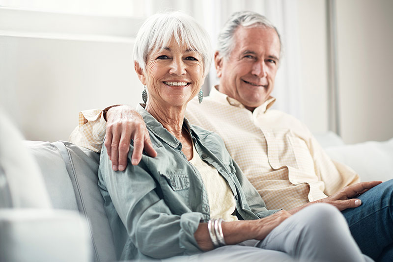 A happy older couple embrace and are confident with their retirement plan